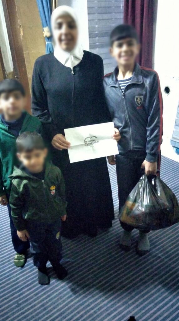 Une mère et ses enfants reçoivent un panier alimentaire du Ramadan, mars 2024